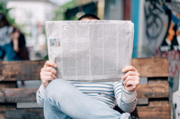 Person hält eine Zeitung.