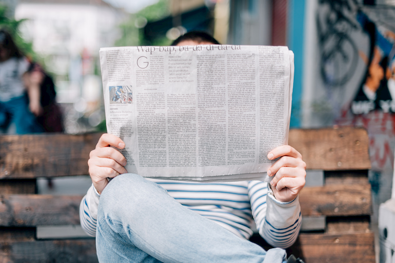 Person hält eine Zeitung.