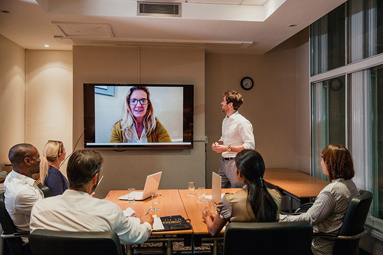 Geschäftsleute halten in einem Büro eine Videokonferenz ab.