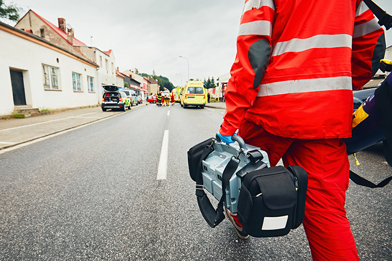 Ein Rettungssanitäter geht auf einen Unfall zu.