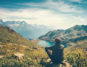 Ein Mann sitzt in den Bergen an einem See und genießt das Sabbatical.