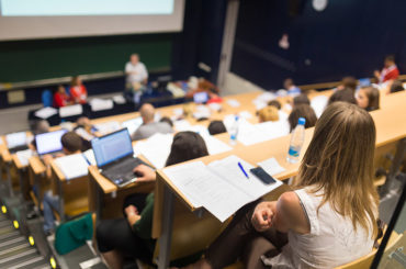 Studenten sitzen in einem Hörsaal einer Universität.