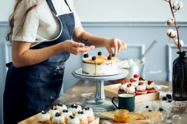 Eine Frau dekoriert einen Kuchen.