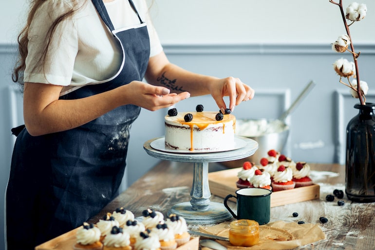 Eine Frau dekoriert einen Kuchen.