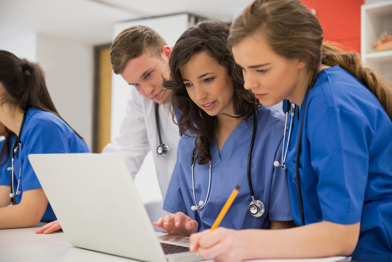 Medizinstudenten sitzen vor einem Laptop.