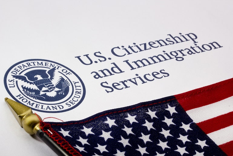 Die amerikanische Flagge liegt über dem Logo der US-Einwanderungsbehörde