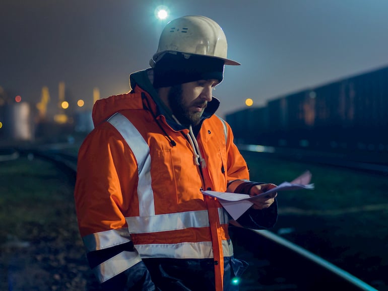 Nachtarbeiter geht seine Unterlagen auf der Baustelle durch