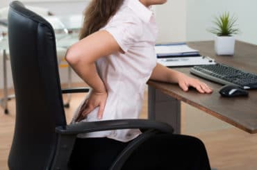 Frau mit schlechter Sitzposition im Homeoffice