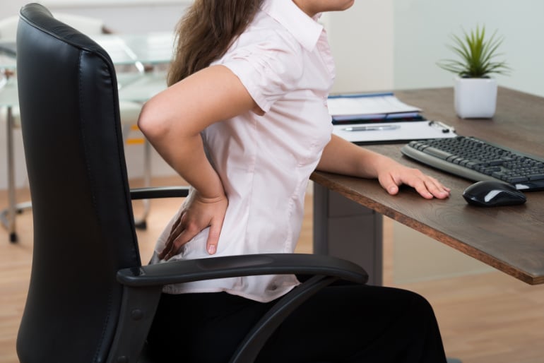 Frau mit schlechter Sitzposition im Homeoffice