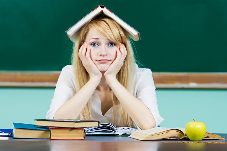 Schülerin mit Buch auf Kopf denkt über Hochschulreife nach