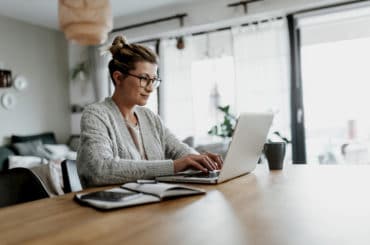 Geschäftsfrau arbeitet im Homeoffice konzentriert am Laptop