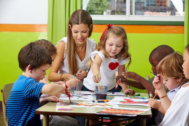 Eine Erzieherin malt mit Kindern