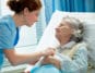 Eine Pflegehelferin kümmert sich um eine Patientin