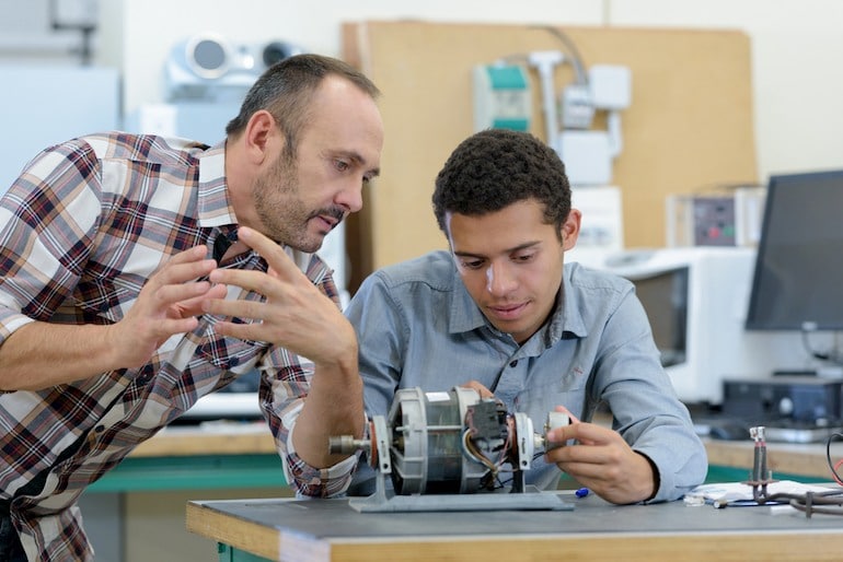 Mechatroniker in der Ausbildung studiert Maschine.