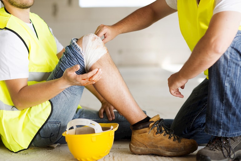 Bauarbeiter versorgt verletzten Kollegen mit Verband