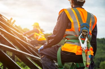 Arbeitnehmer berücksichtigt den Arbeitsschutz und sichert sich mit einem Seil