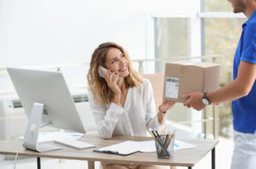 Assistentin der Geschäftsführung nimmt Paket an.