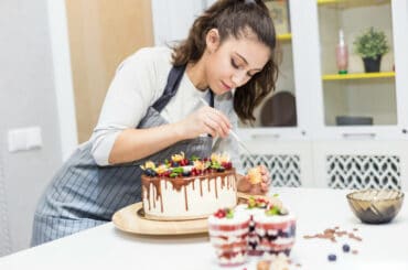 Eine Konditorin verziert eine Torte.