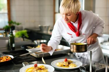 Koch richtet Speisen in einer Restaurantküche an