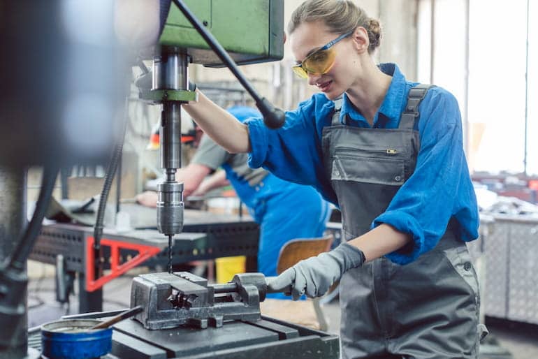 Eine Metallbauerin arbeitet an einer Maschine