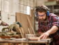 Ein Tischler schneidet in seiner Werkstatt Holz zu