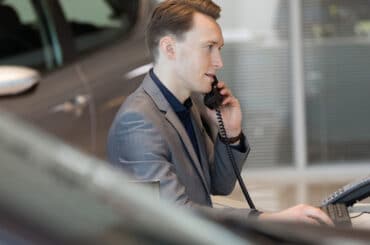 Automobilkaufmann telefoniert mit Kunden