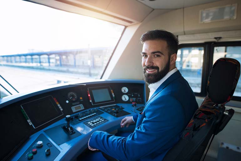 Ein Lokführer sitzt in der Fahrerkabine eines Zuges