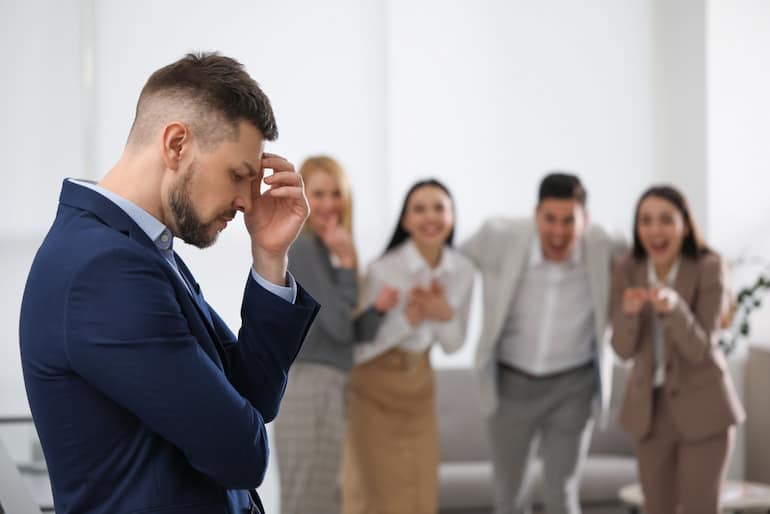 Ein Arbeitnehmer erfährt Mobbing am Arbeitsplatz durch seine Kollegen