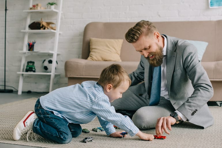 Ein Geschäftsmann spielt mit seinem Sohn und hat eine gesunde Work-Life-Balance