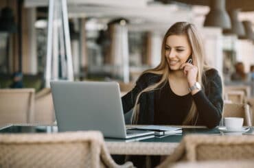 Eine Freelancerin arbeitet in einem Café an ihrem Laptop