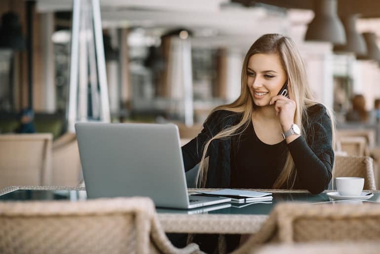 Eine Freelancerin arbeitet in einem Café an ihrem Laptop