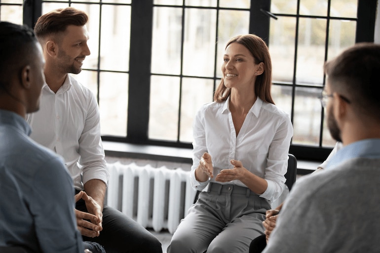 Eine Psychologin führt ein Gruppengespräch in einem Unternehmen