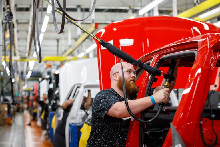 Produktionshelfer setzt Airbag in ein Auto ein.